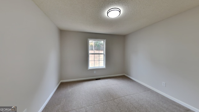 empty room with a textured ceiling and carpet