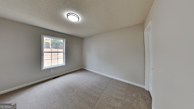 spare room featuring a textured ceiling and carpet floors