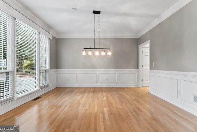 unfurnished dining area featuring ornamental molding and light wood-type flooring