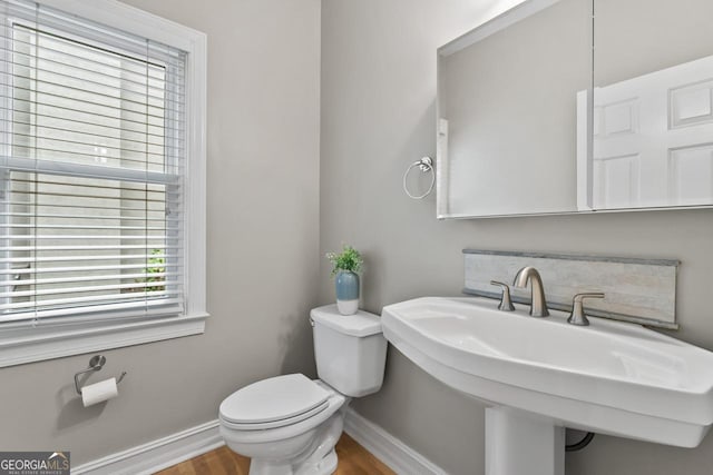 bathroom featuring wood-type flooring, toilet, and sink