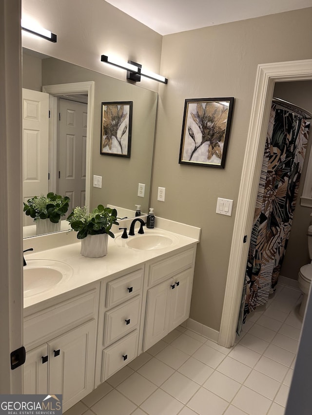 bathroom featuring tile patterned flooring, vanity, and toilet