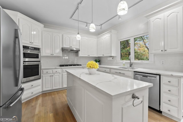 kitchen with white cabinetry, stainless steel appliances, a kitchen island, and pendant lighting