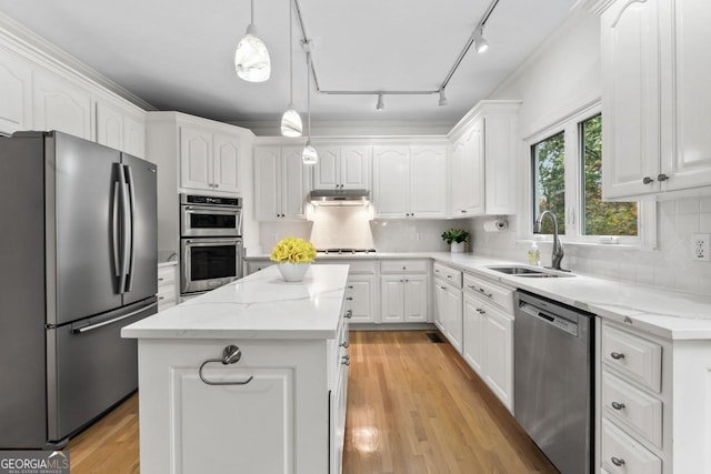 kitchen with sink, decorative light fixtures, a center island, stainless steel appliances, and white cabinets