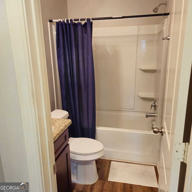 full bathroom featuring toilet, vanity, hardwood / wood-style floors, and shower / bathtub combination with curtain