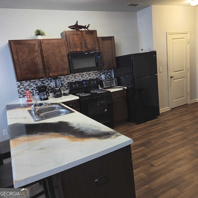 kitchen with sink, black appliances, backsplash, dark brown cabinets, and dark hardwood / wood-style flooring