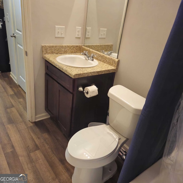 bathroom featuring toilet, vanity, and wood-type flooring