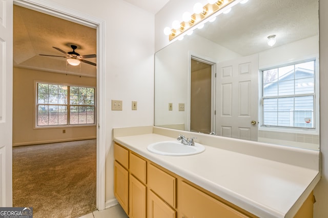 bathroom with lofted ceiling, a textured ceiling, ceiling fan, and a healthy amount of sunlight