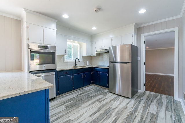 kitchen with light hardwood / wood-style floors, stainless steel refrigerator, crown molding, blue cabinets, and white cabinets