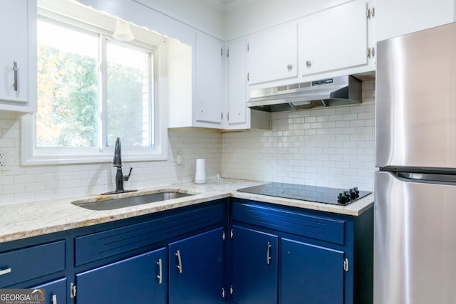 kitchen with blue cabinets, white cabinetry, extractor fan, and stainless steel refrigerator