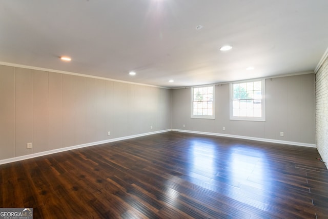 empty room featuring dark wood-type flooring and crown molding