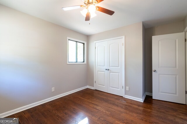 unfurnished bedroom featuring a closet, ceiling fan, and dark hardwood / wood-style floors