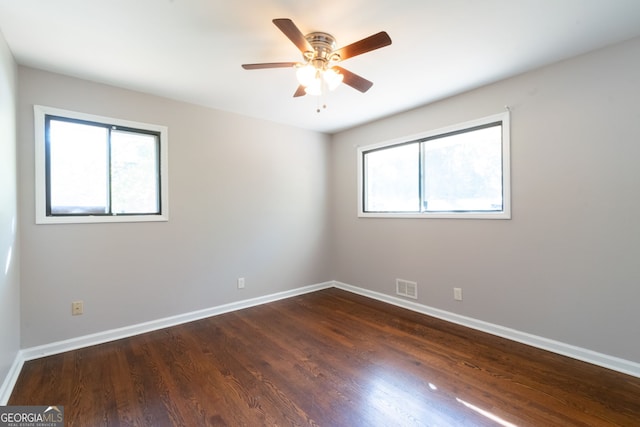 empty room with dark wood-type flooring and ceiling fan