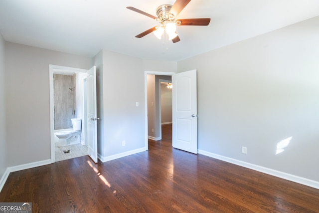 unfurnished bedroom with ceiling fan, dark hardwood / wood-style floors, and connected bathroom