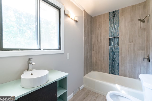 full bathroom with toilet, vanity, tiled shower / bath combo, and a wealth of natural light