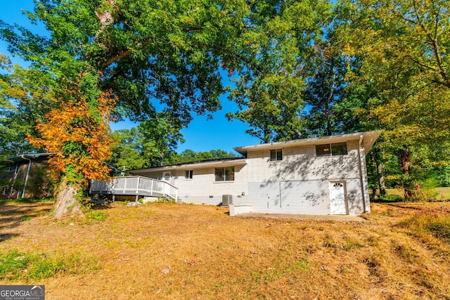 rear view of house featuring a yard and a deck