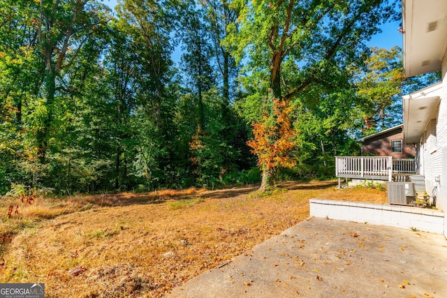 view of yard featuring central AC unit and a wooden deck