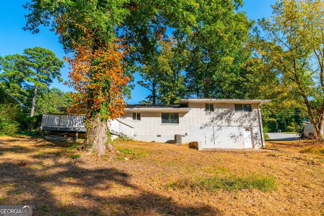 back of property featuring cooling unit, a lawn, and a deck