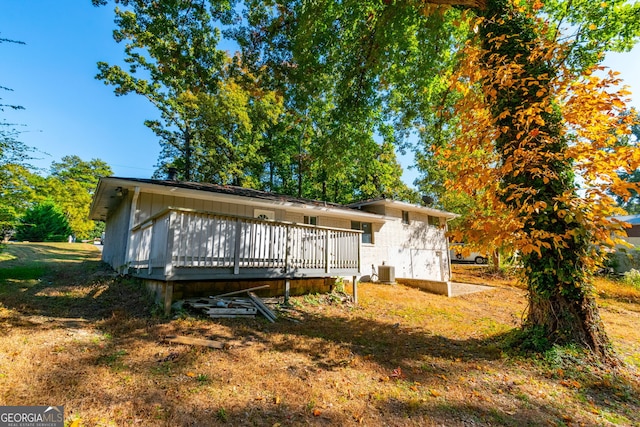 back of house with central air condition unit and a deck