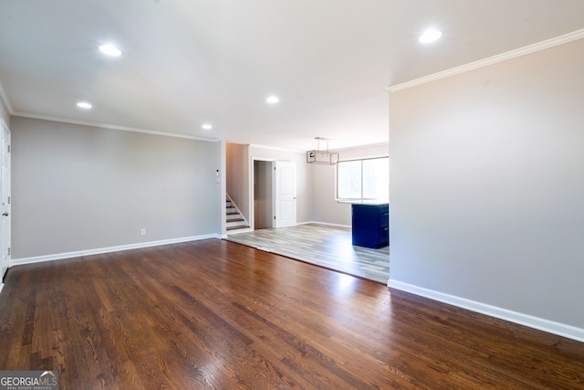 unfurnished living room with ornamental molding and dark hardwood / wood-style floors