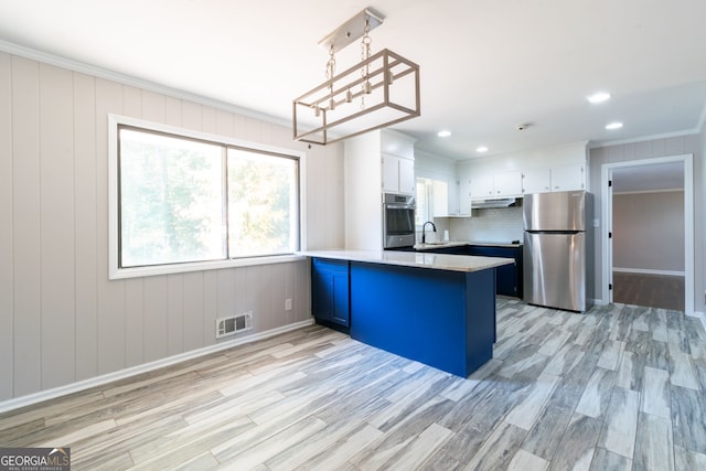 kitchen featuring white cabinetry, appliances with stainless steel finishes, decorative light fixtures, and light hardwood / wood-style floors