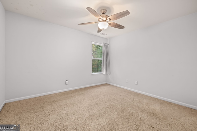 unfurnished room with ceiling fan and carpet