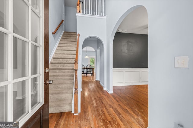 entryway with a towering ceiling and hardwood / wood-style floors