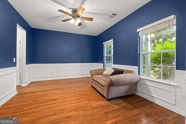 living area featuring plenty of natural light, wood-type flooring, and ceiling fan