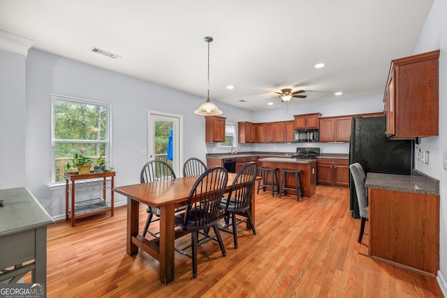 dining room featuring light wood-type flooring, plenty of natural light, and ceiling fan