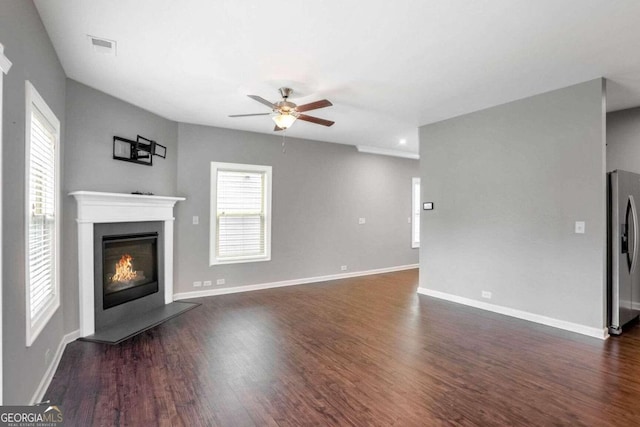 unfurnished living room with dark wood-type flooring and ceiling fan