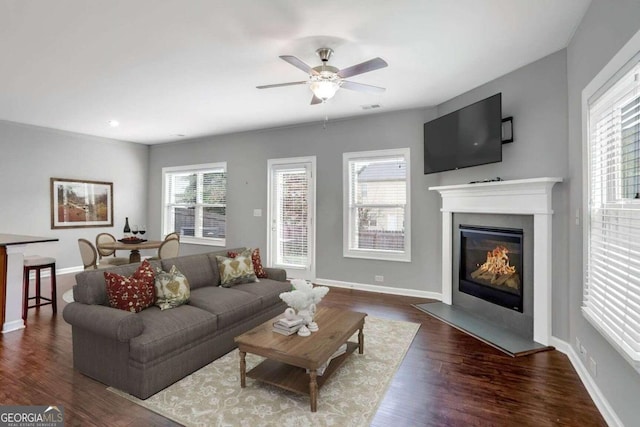 living room featuring plenty of natural light, ceiling fan, and dark hardwood / wood-style flooring