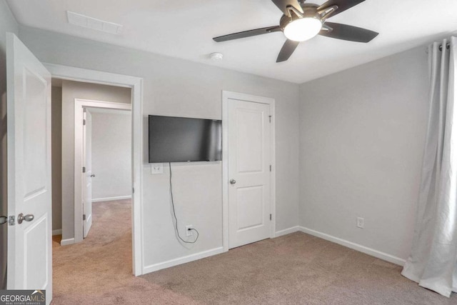 unfurnished bedroom with light colored carpet and ceiling fan