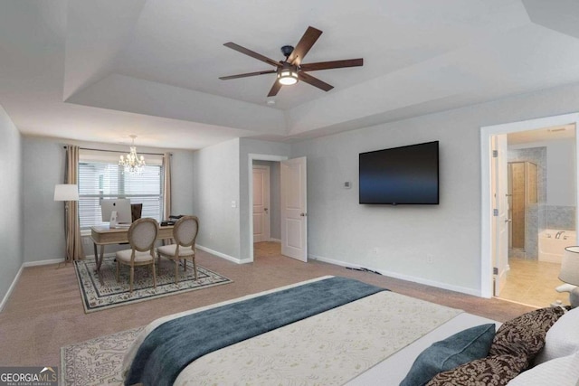 bedroom with ensuite bathroom, a tray ceiling, ceiling fan with notable chandelier, and carpet floors