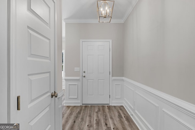 doorway to outside featuring light hardwood / wood-style floors, a chandelier, and ornamental molding