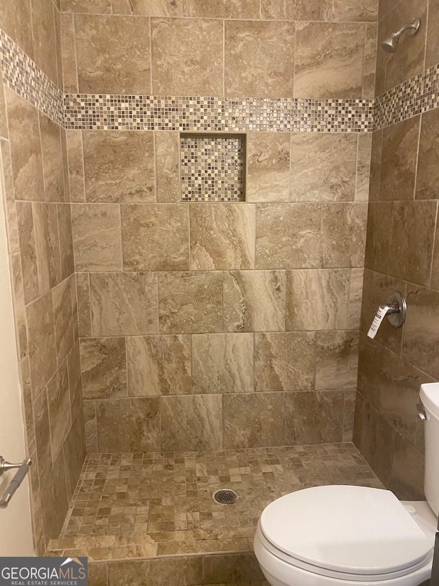 bathroom with tiled shower and toilet