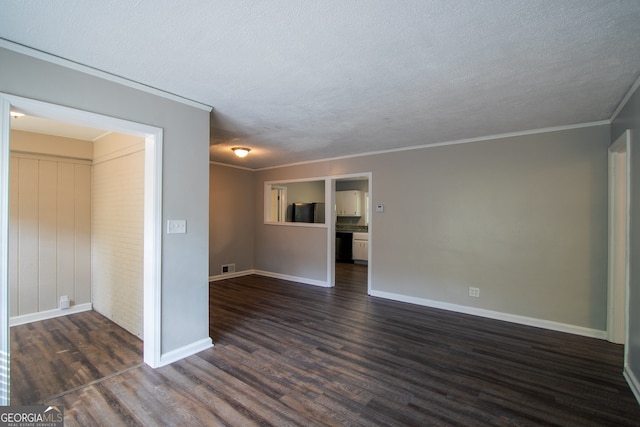 empty room with dark wood-type flooring, a textured ceiling, and ornamental molding