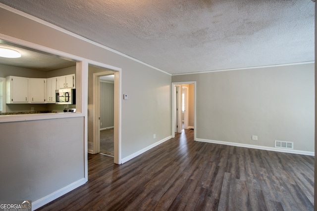 unfurnished living room with dark hardwood / wood-style flooring, a textured ceiling, and crown molding