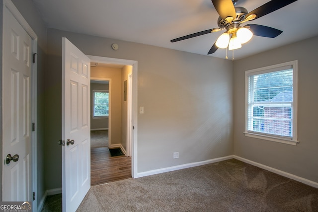 carpeted empty room featuring ceiling fan and a healthy amount of sunlight