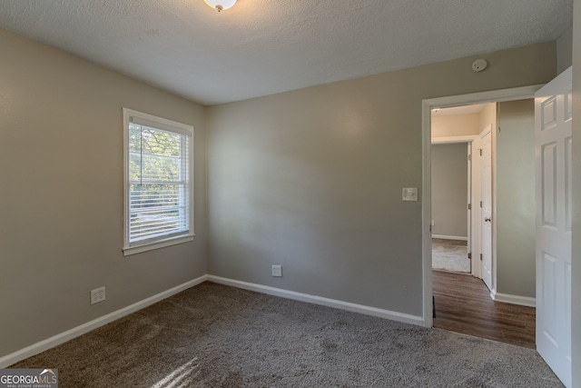 carpeted spare room with a textured ceiling