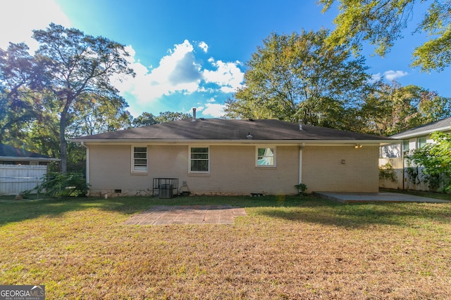 rear view of property with a patio and a lawn