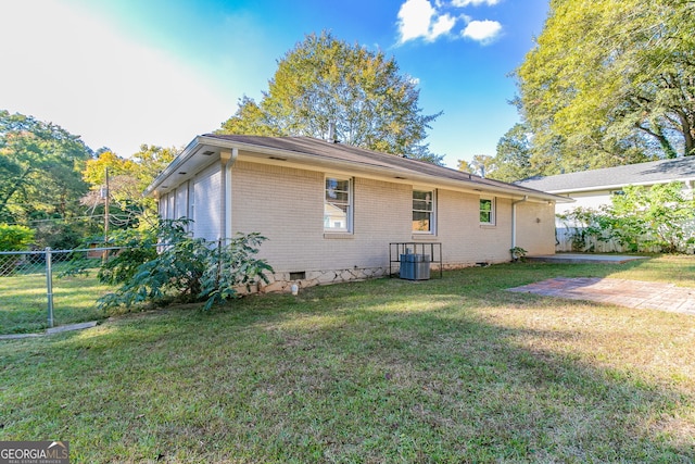 view of side of home featuring central air condition unit, a lawn, and a patio area