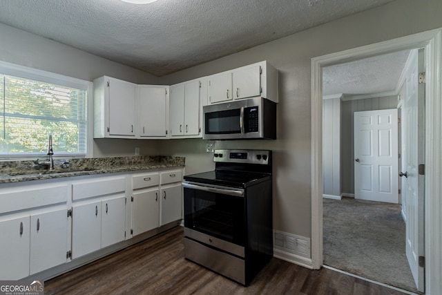 kitchen with dark hardwood / wood-style flooring, appliances with stainless steel finishes, sink, and white cabinets