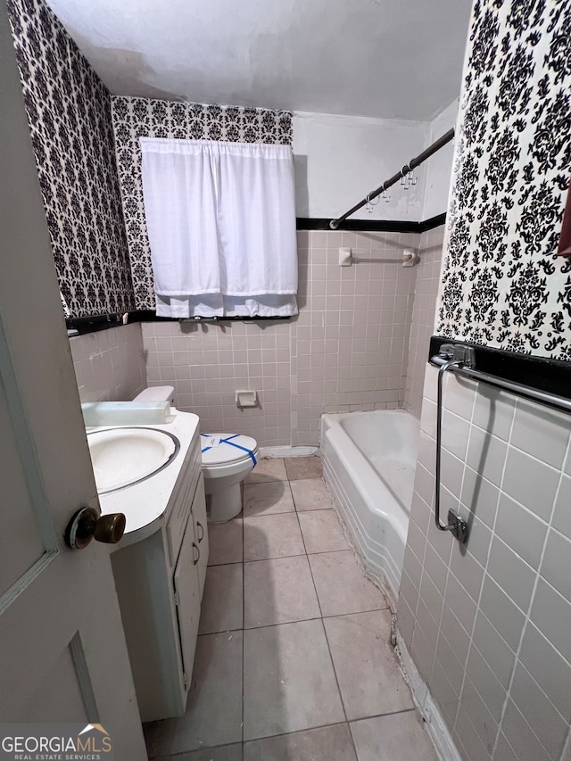 bathroom featuring tile patterned flooring, vanity, tile walls, and toilet