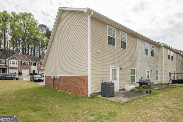 back of property with central air condition unit, a yard, and a garage