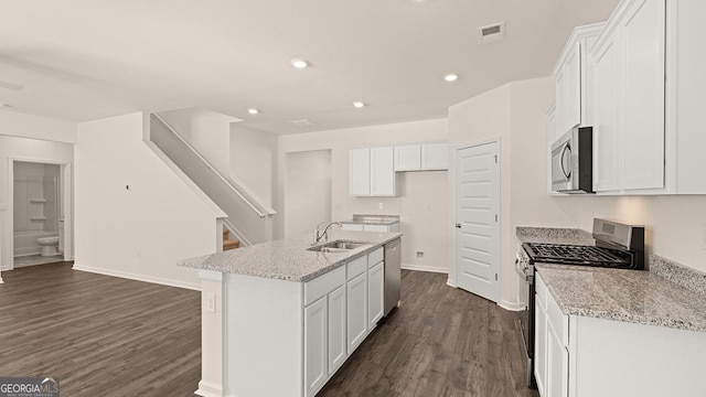 kitchen featuring stainless steel appliances, an island with sink, sink, and white cabinets