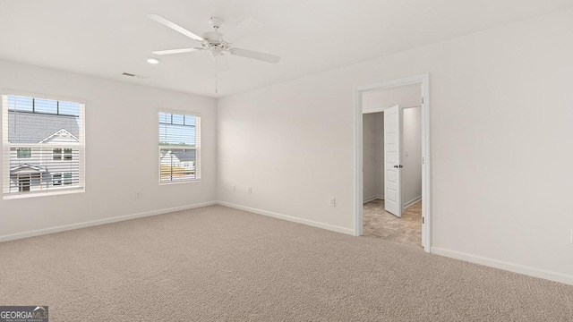 carpeted spare room with ceiling fan