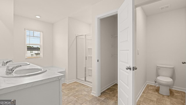 bathroom with an enclosed shower, vanity, and toilet