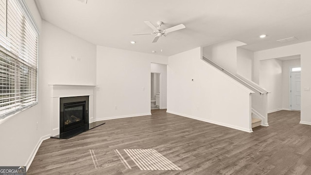 unfurnished living room featuring ceiling fan, a healthy amount of sunlight, and wood-type flooring