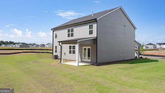 rear view of house featuring a yard, a patio area, and central air condition unit