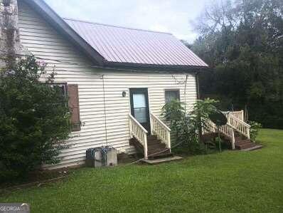 rear view of house featuring a yard