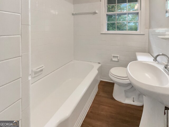 bathroom featuring tile walls, hardwood / wood-style floors, and toilet